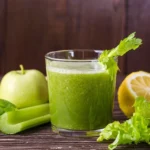 Fresh green smoothie made with celery, apple, lettuce, and lemon, garnished with a celery stick